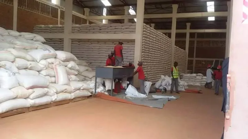Workers stacking grain sacks in a warehouse