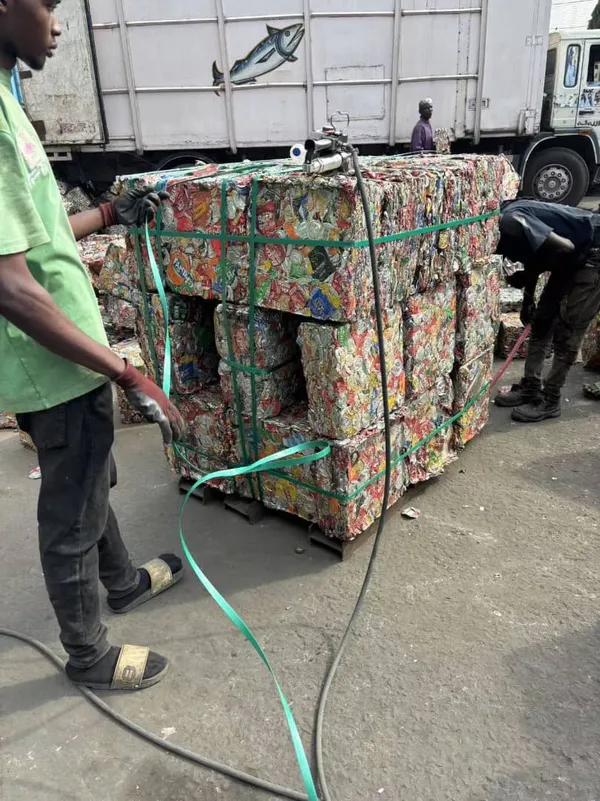 A worker handling a bale of recovered material